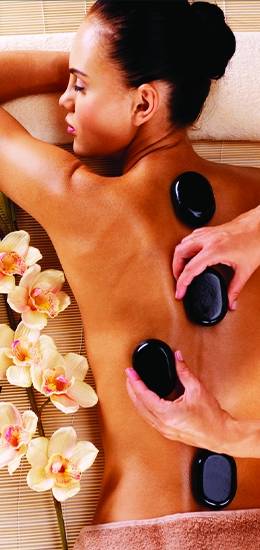 female client is taking hot stone massage therapy in Glory massage center Faisalabad